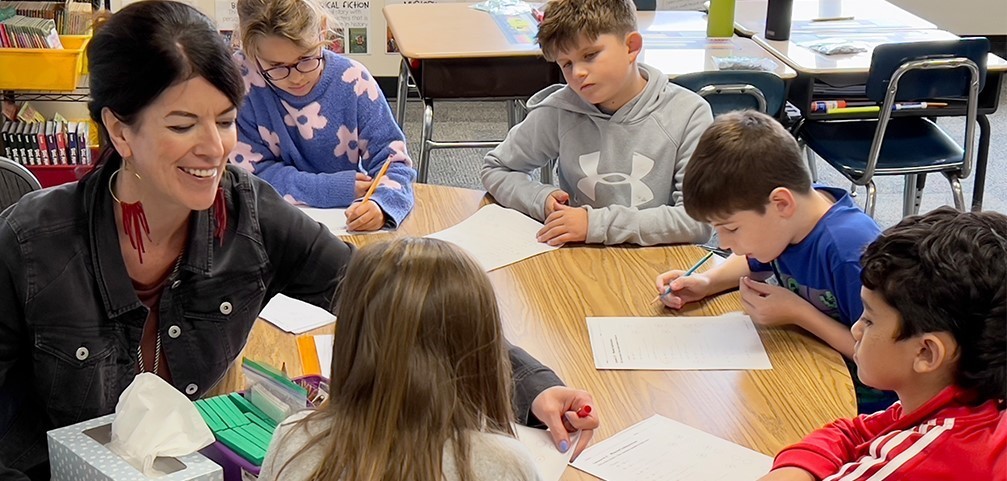 Lions Park teacher at table with students.